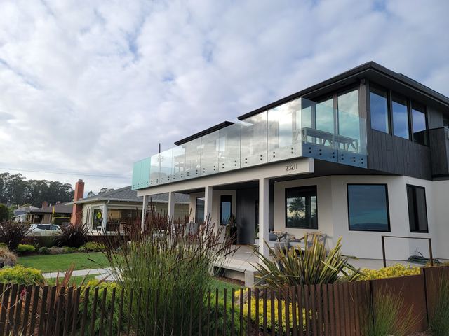 Glass balcony railing on a two-story modern house