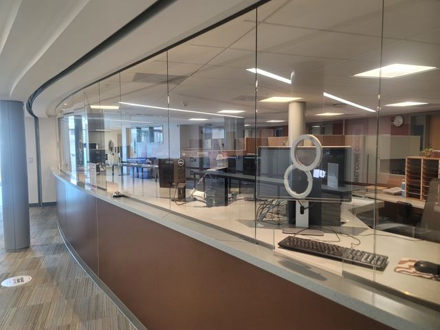 Curved glass partition mounted above a service counter