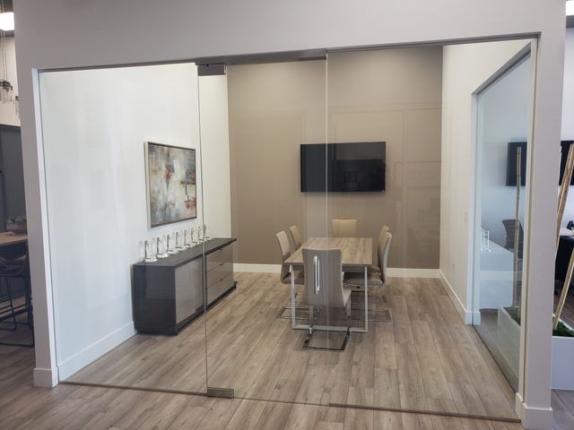 Frameless glass conference room with a sliding glass door