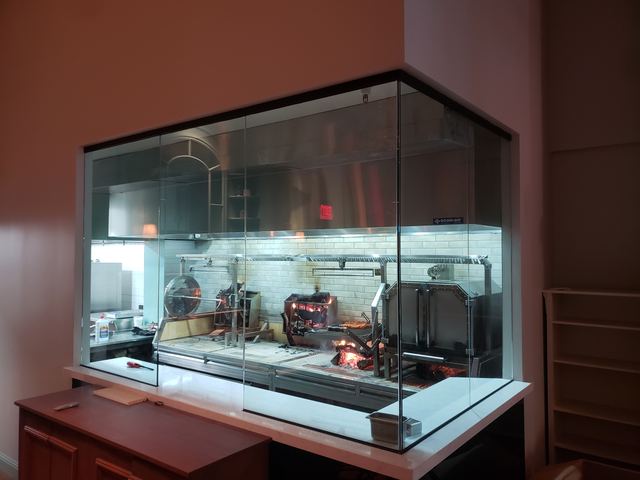 Glass enclosure around an open restaurant kitchen cooking line