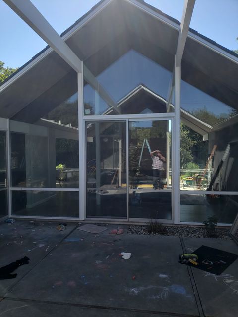 Gabled glass wall with new double-pane low-E insulated glass and a new patio door facing a courtyard
