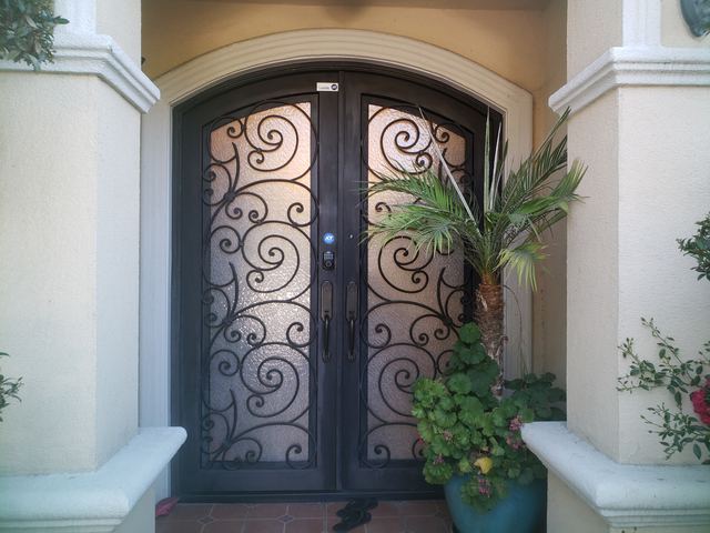 Wrought-iron double entry door with textured glass inserts