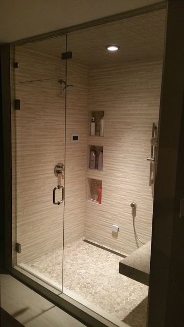 Ceiling-height frameless steam shower enclosure with hinged door and brushed nickel hardware